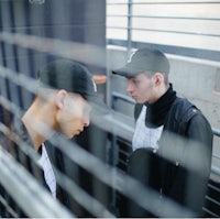 two men looking at each other in a cage