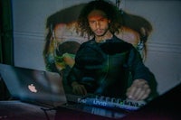 a man playing a dj with a laptop in front of him